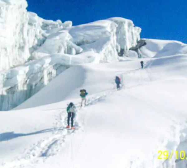 A group of climbers ascending a snowy ridge toward the summit of a Peak in the Nepal Himalayas.