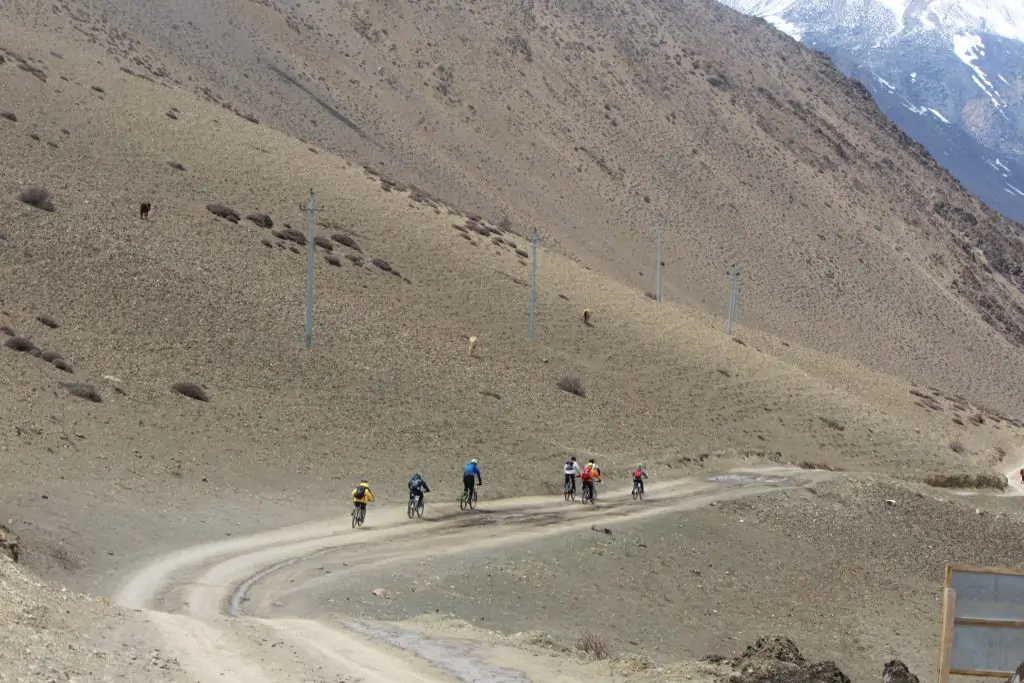A distant view of a group of riders biking along a scenic trail in upper mustang trek.