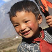 Portrait of a cheerful local boy smiling warmly around Tsum Valley Trekking