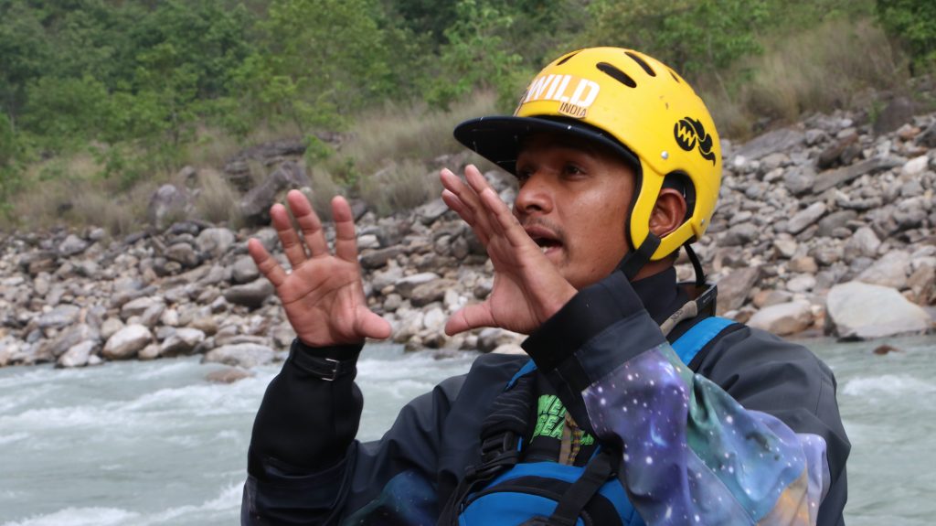 Instructor conducting a river guide assessment and training session outdoors, teaching rafting safety and techniques.