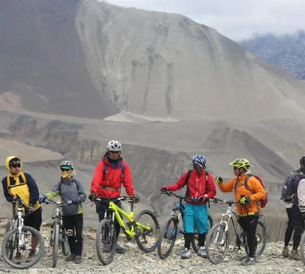 A group of riders enjoying a scenic trail with the mountain range in the background.