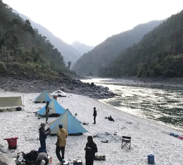Group of people gearing up and preparing their rafts on the banks of the Karnali River.