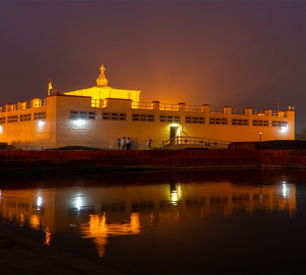 Night view of Lumbini with soft lighting around the Maya Devi Temple and tranquil reflections in the sacred pond.