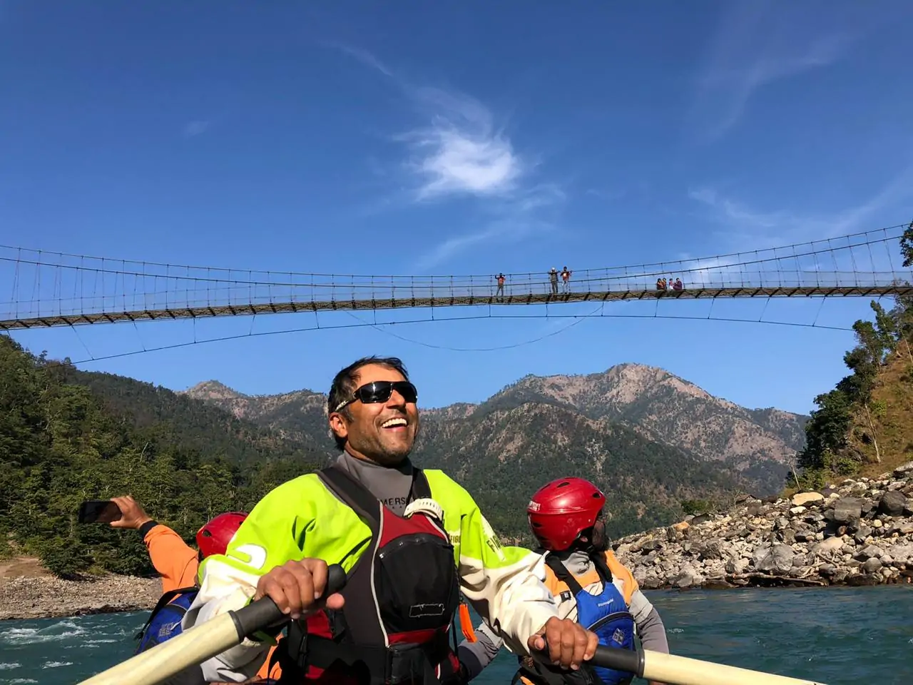 Group of people happily rafting through rapids on the Karnali River