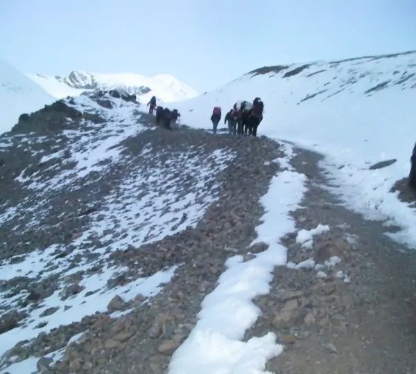 A group of trekkers walking along a trail surrounded by mountains on the way to Mardi Himal Base Camp in Nepal.