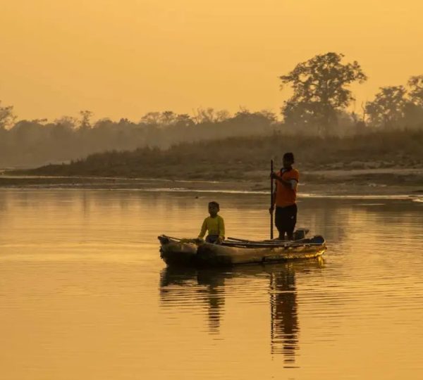 Traditional wooden canoe floating on the calm Geruwa River.