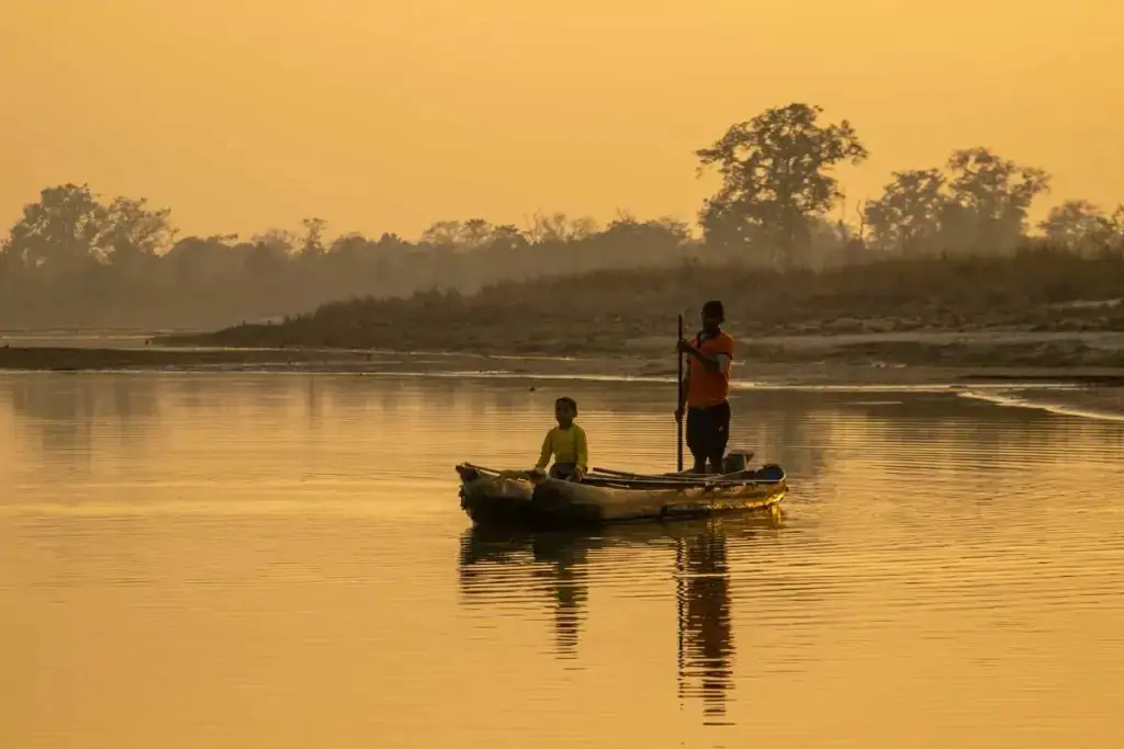 Traditional wooden canoe floating on the calm Geruwa River.
