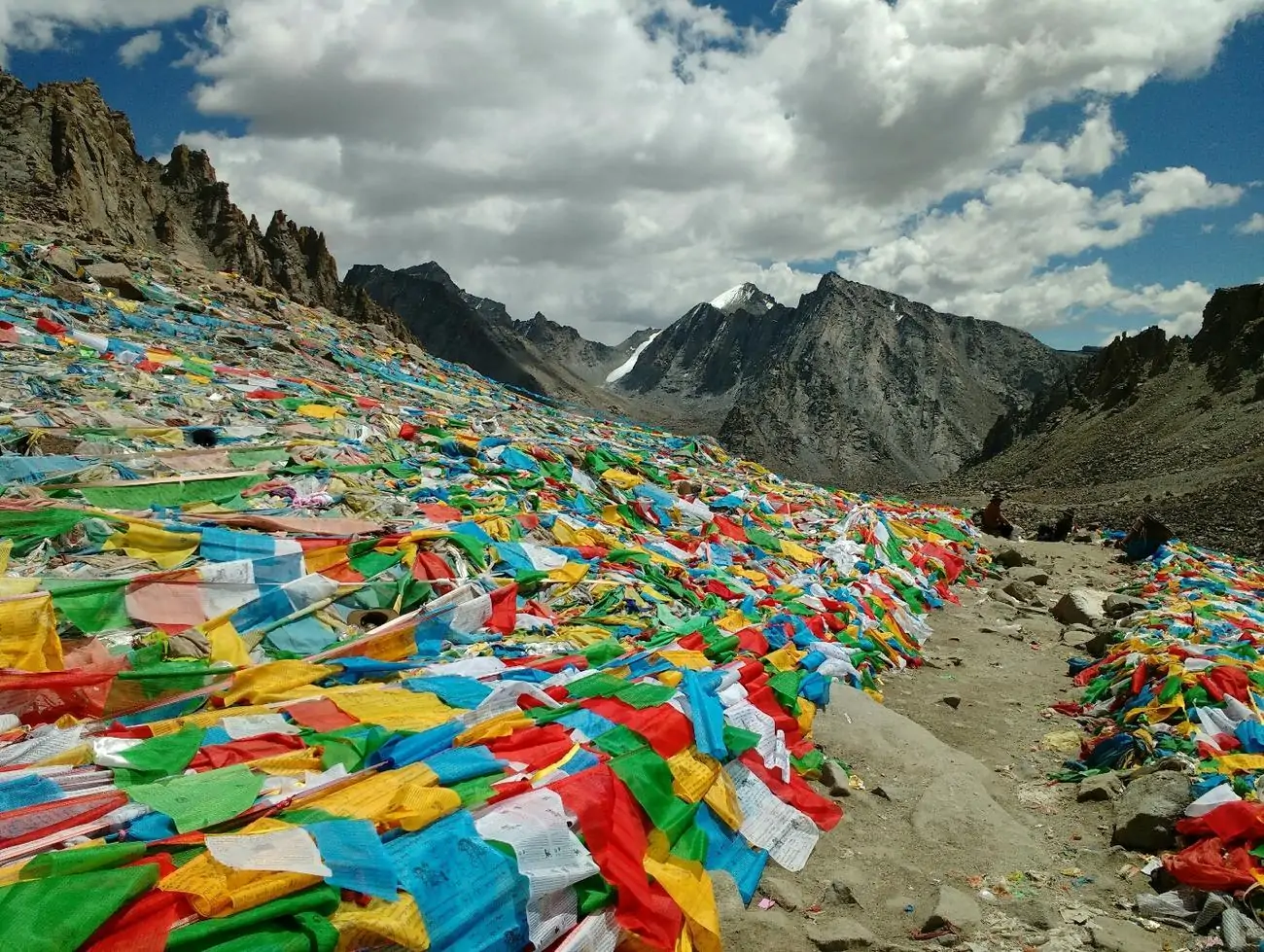 Vibrant prayer flags fluttering along a mountain trail in the Himalayas, symbolizing peace and blessings for trekkers.