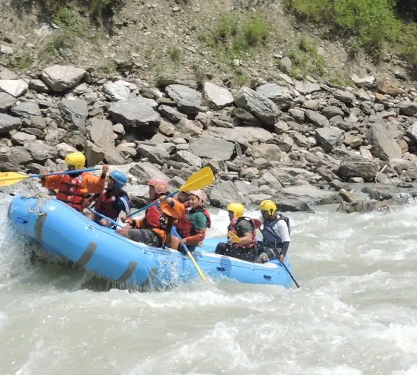 A group of rafters paddling in unison while maneuvering through rapids on the Tamor River, Eastern Nepal.