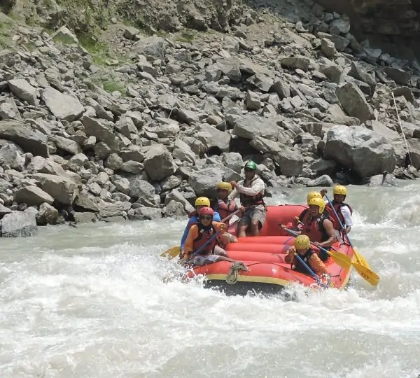 Calm stretch of the Tamor River flowing gently between forested hills and mountainous terrain during a rafting trip in Nepal.