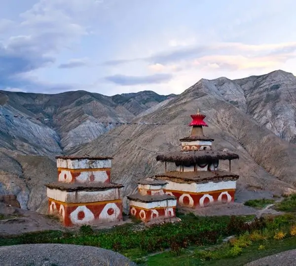 Vast and rugged terrain of Upper Dolpo with arid valleys, high mountain passes, and scattered traditional stone houses under a clear sky.