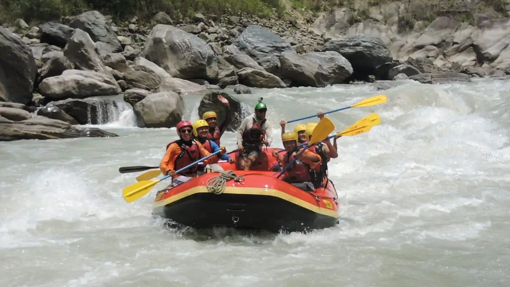 Close-up of a rafter wearing safety gear, expertly steering a raft through rough whitewater on the Tamor River in Nepal.