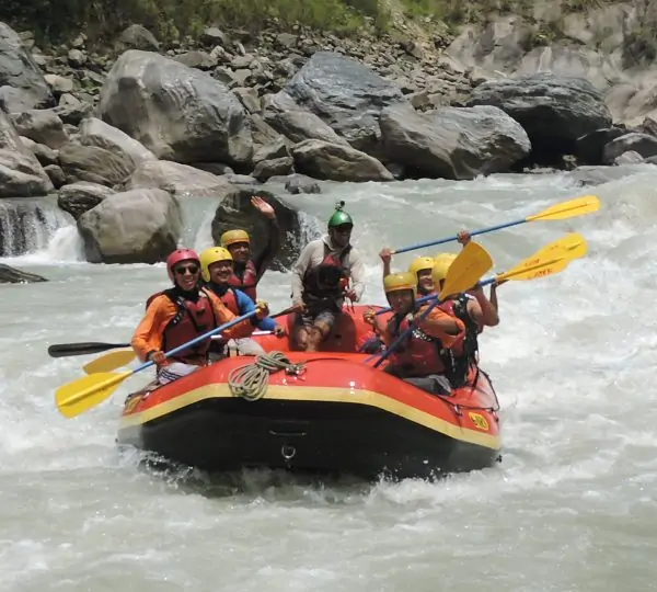 Close-up of a rafter wearing safety gear, expertly steering a raft through rough whitewater on the Tamor River in Nepal.